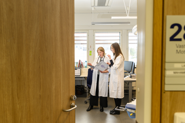 Kaksi lääkäriä työskentelee vastaanottohuoneessa.